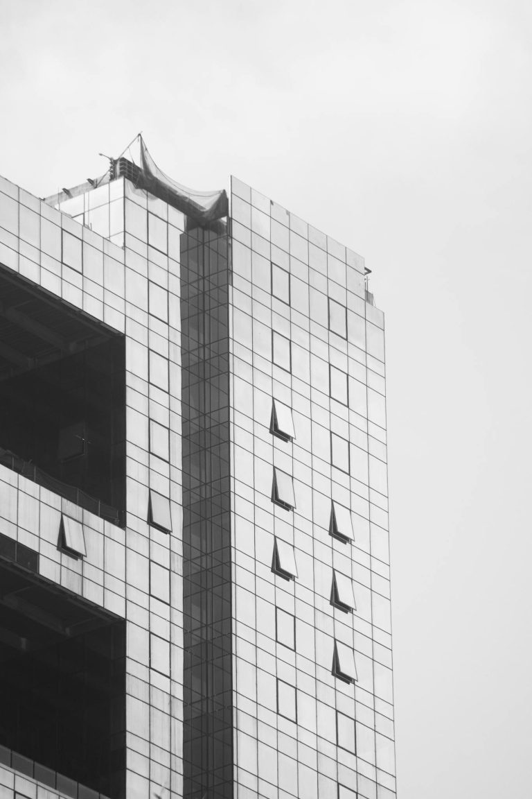 A sleek modern skyscraper with a reflective glass facade dominates the cityscape.